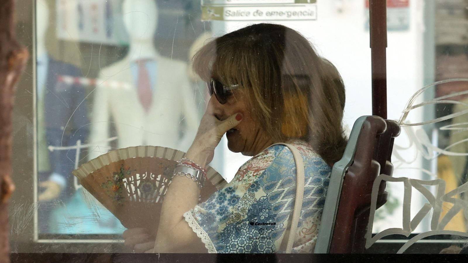 Una mujer con abanico viajando en el interior de un autobús urbano de Jerez