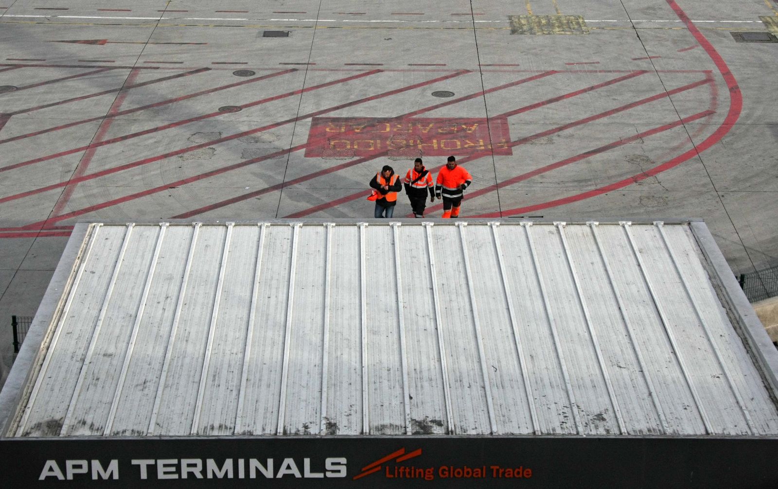 Tres estibadores se disponen a salir de una de las terminales del puerto de Algeciras, el pasado viernes.