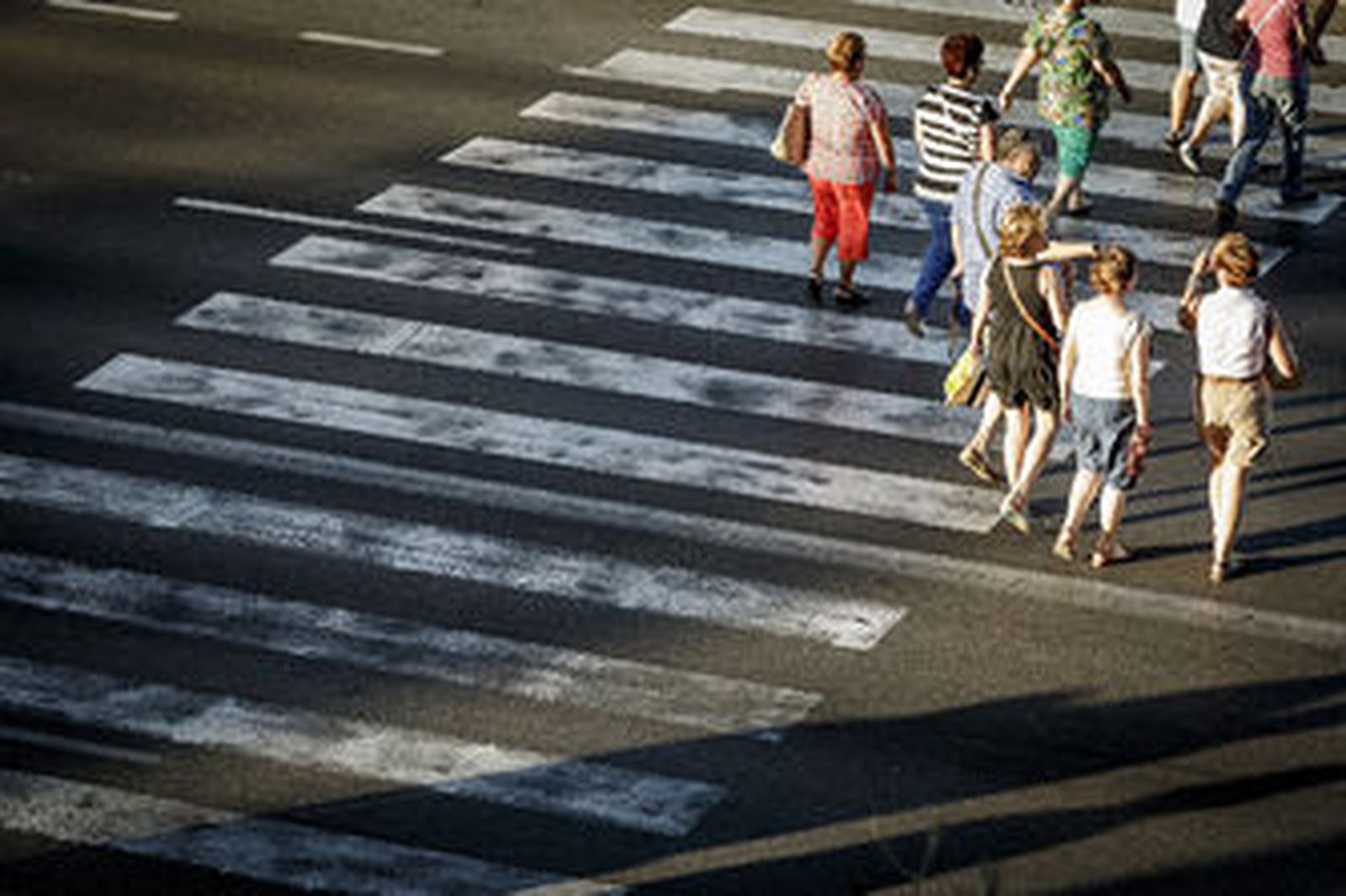 Peatones cruzando, mal, por un paso de cebra.