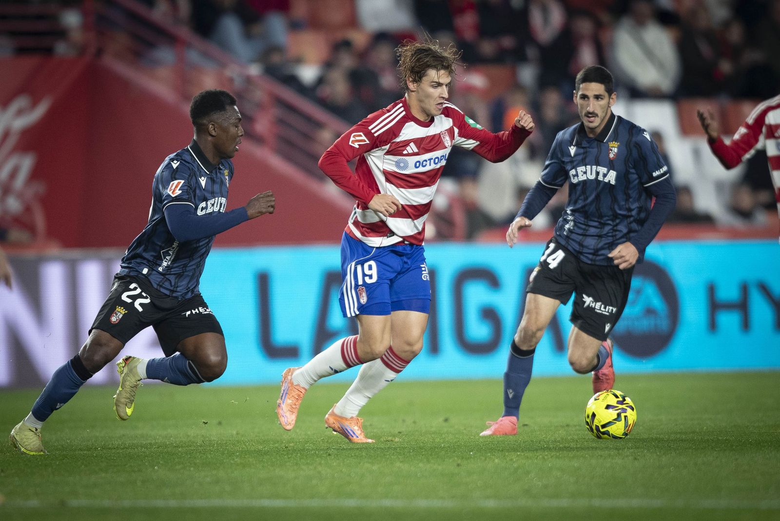 Jorge Pascual rodeado de dos jugadores del Ceuta en el partido de la primera vuelta.