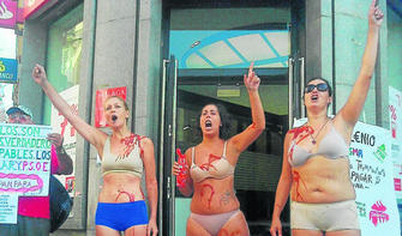 Tres de las mujeres, en ropa interior, en la puerta del banco.