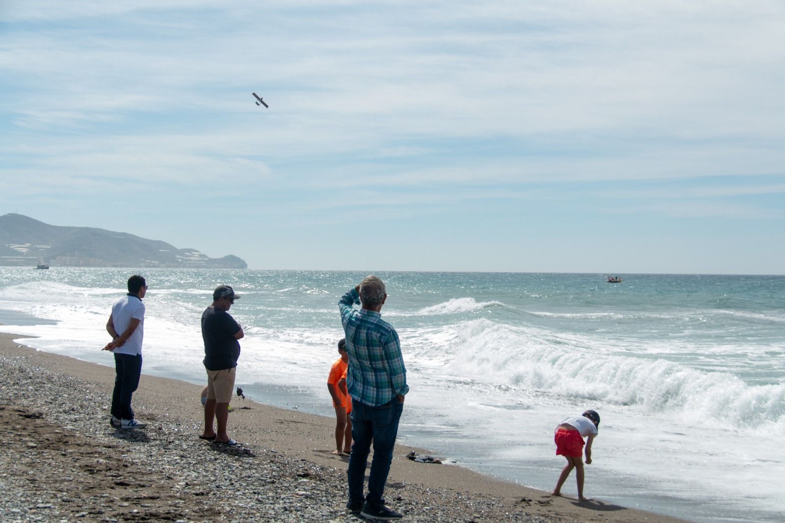 Varias personas disfrutan del espectáculo aéreo de ayer ante un mar con oleaje.