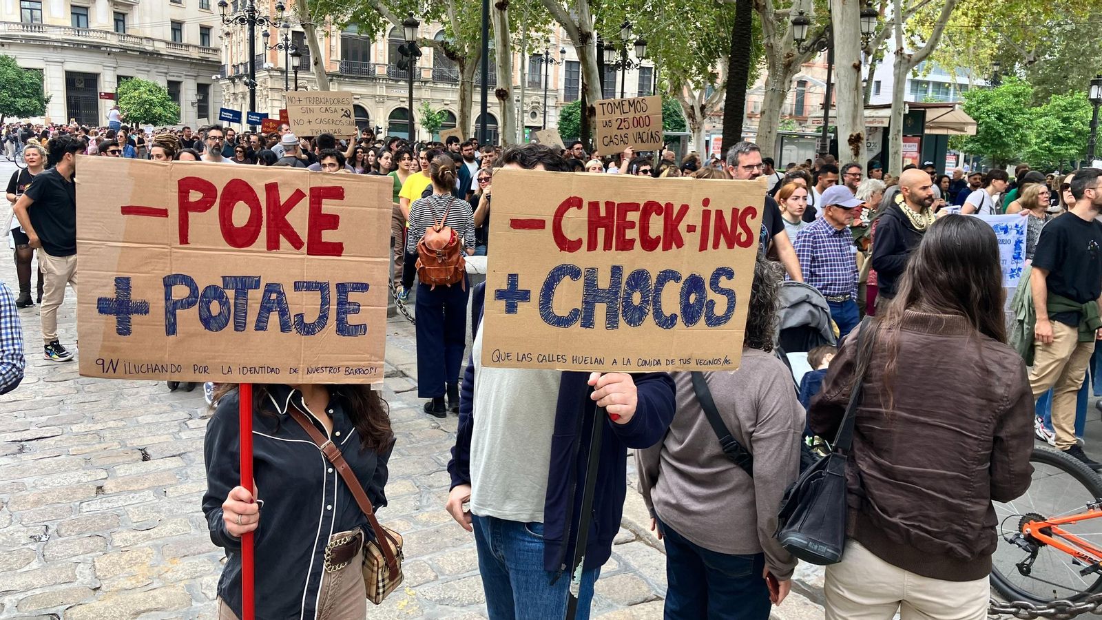 Dos manifestantes posan con dos originales mensajes al paso de la manifestación por la Plaza Nueva.