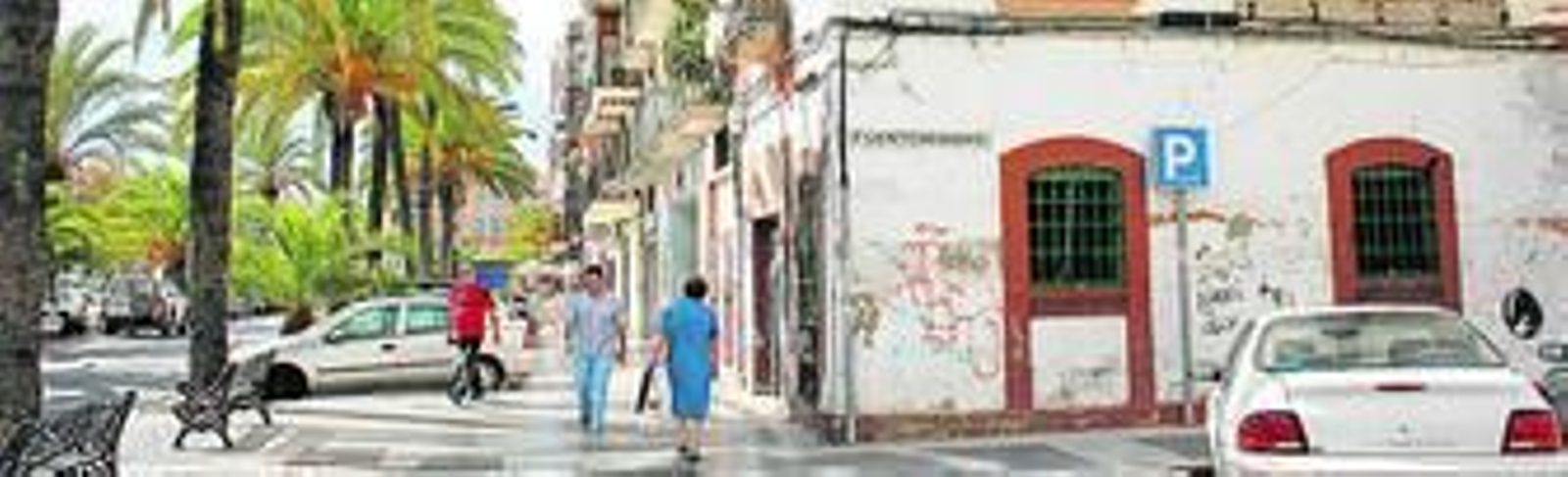 Imagen del Paseo de las Palmeras en su esquina con la calle Fuenteheridos, dos de las vías principales del Molino de la Vega, donde aún está en pie un edificio de épocas pasadas.
