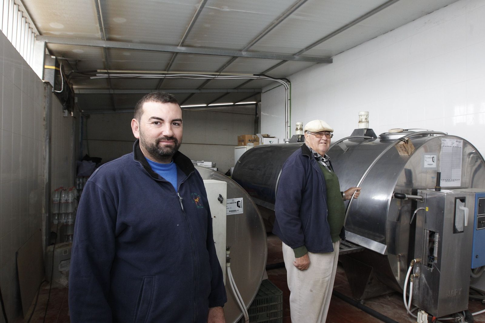 Francisco García junto a su padre en la sala de almacenaje de la leche de cabra