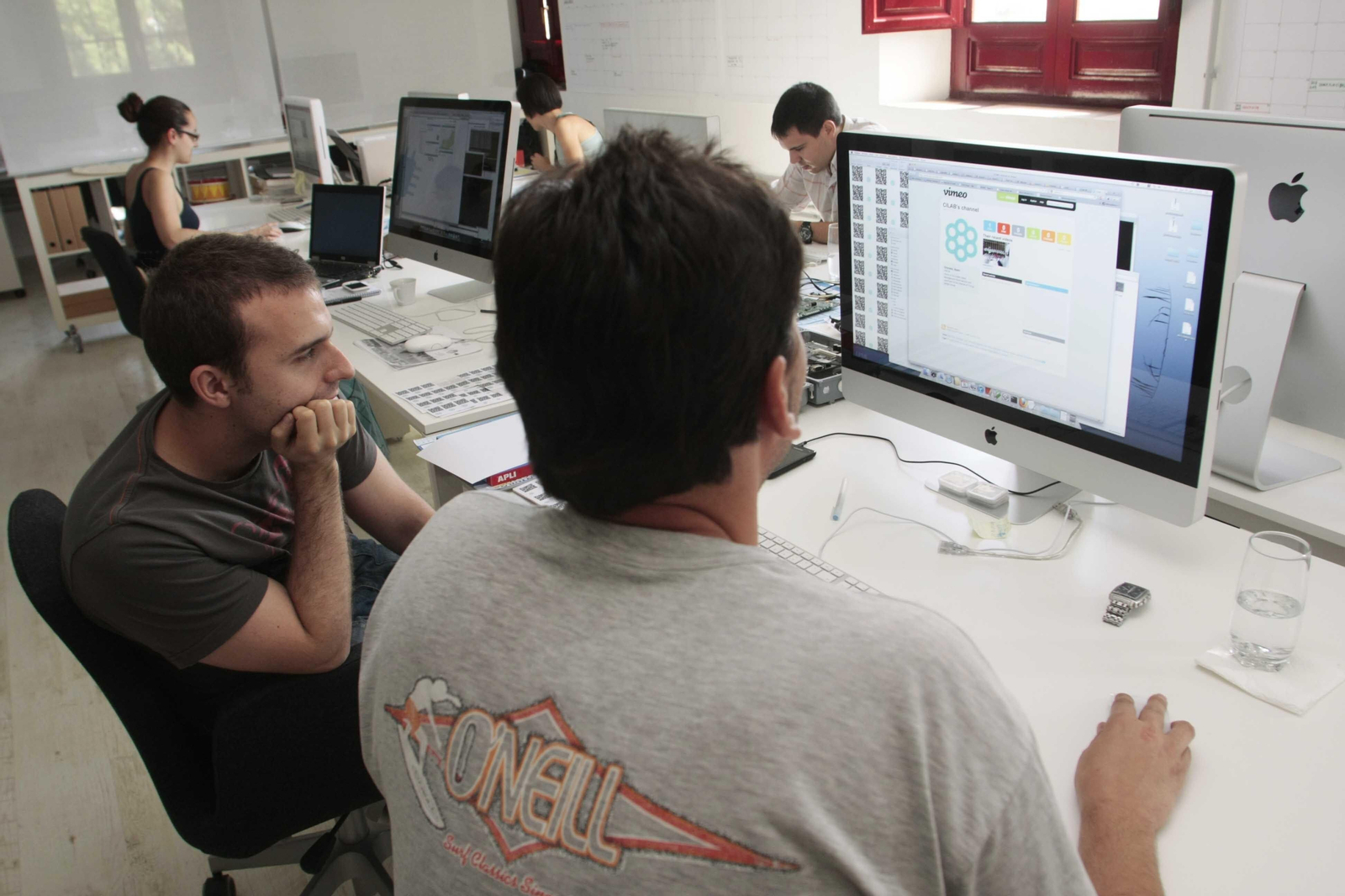 imagen de archivo de dos trabajadores frente a un ordenador en una empresa tecnológica de Granada
