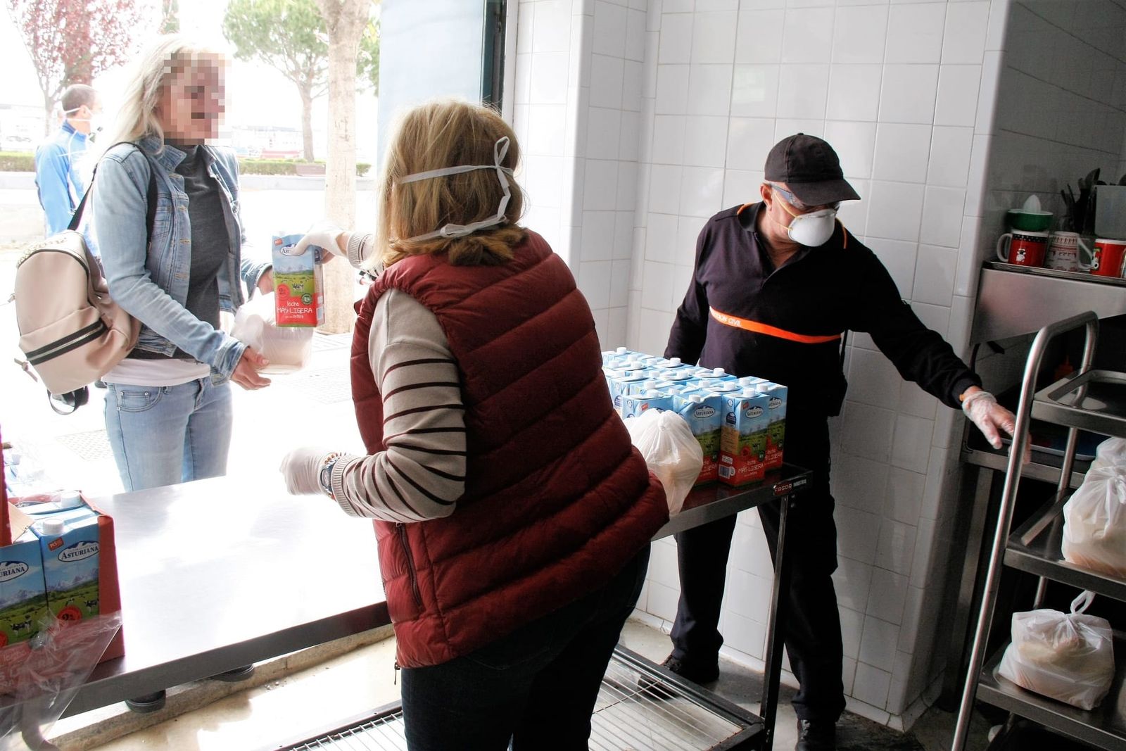 La edil Carmen Lara, de espaldas, durante un reparto de alimentos en los primeros días del confinamiento.