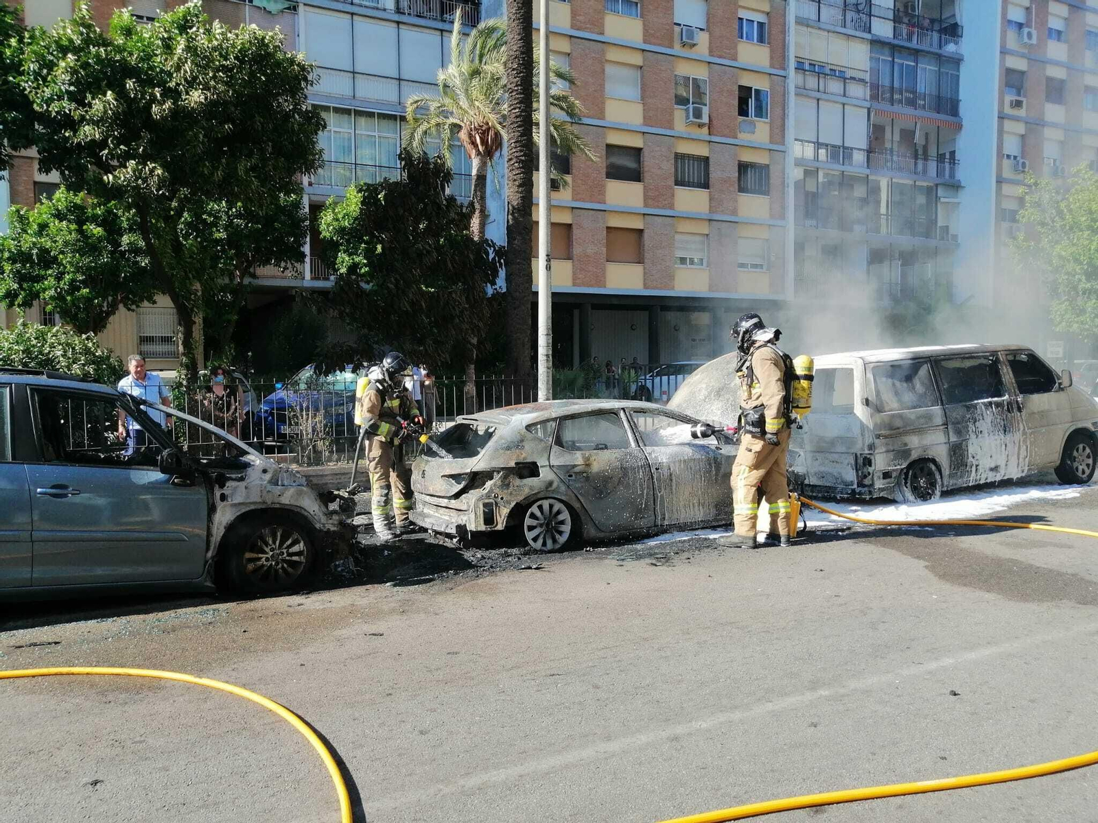 Los Bomberos apagan uno de los coches incendiados en Los Remedios el pasado jueves.