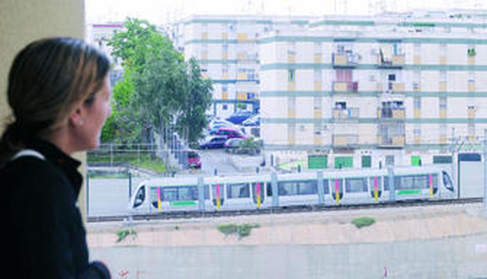 Una vecina de Cornisa Azul observa el paso del Metro junto a los bloques de Virgen del Rocío.