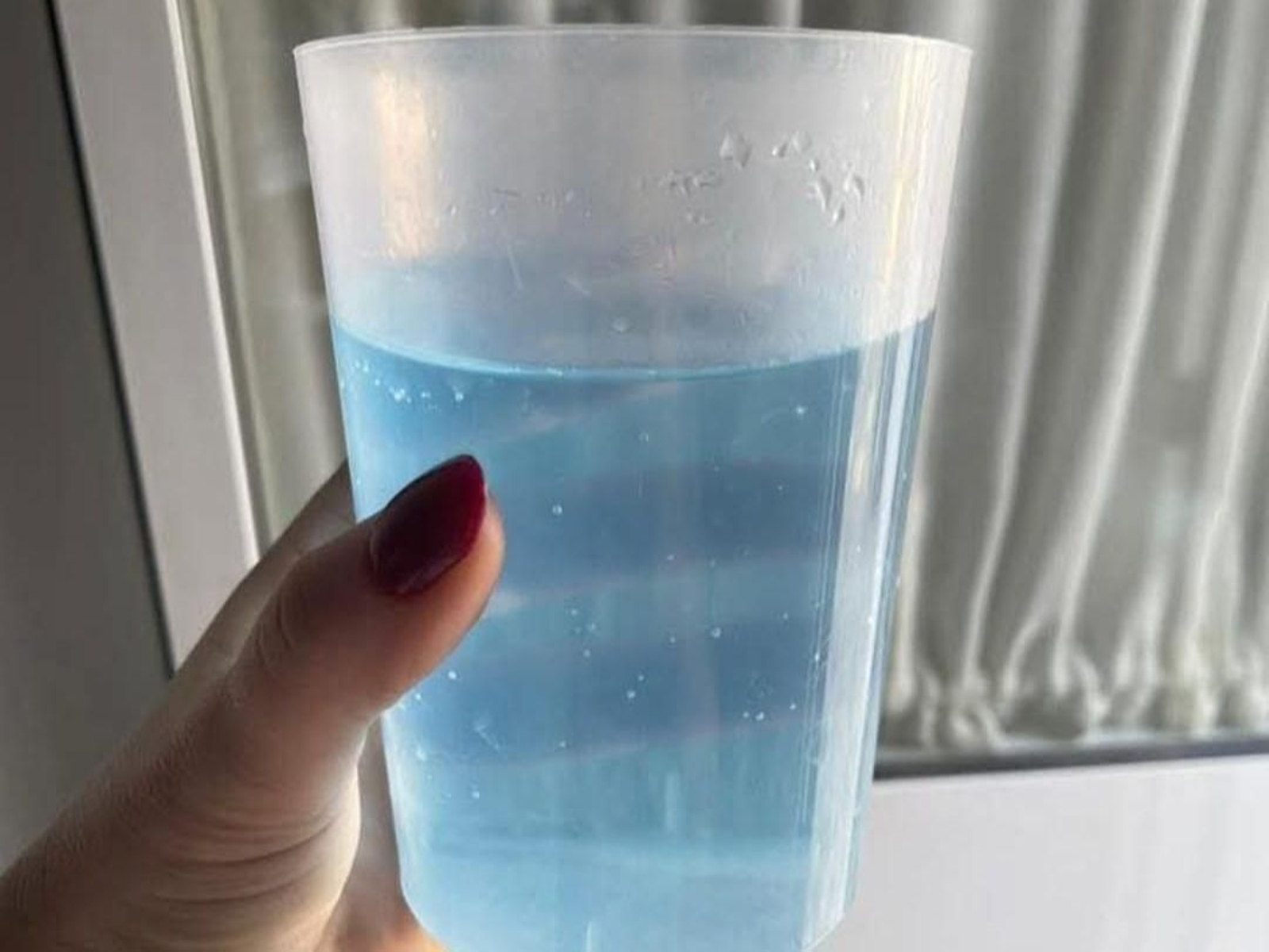 Agua azul en un vaso.