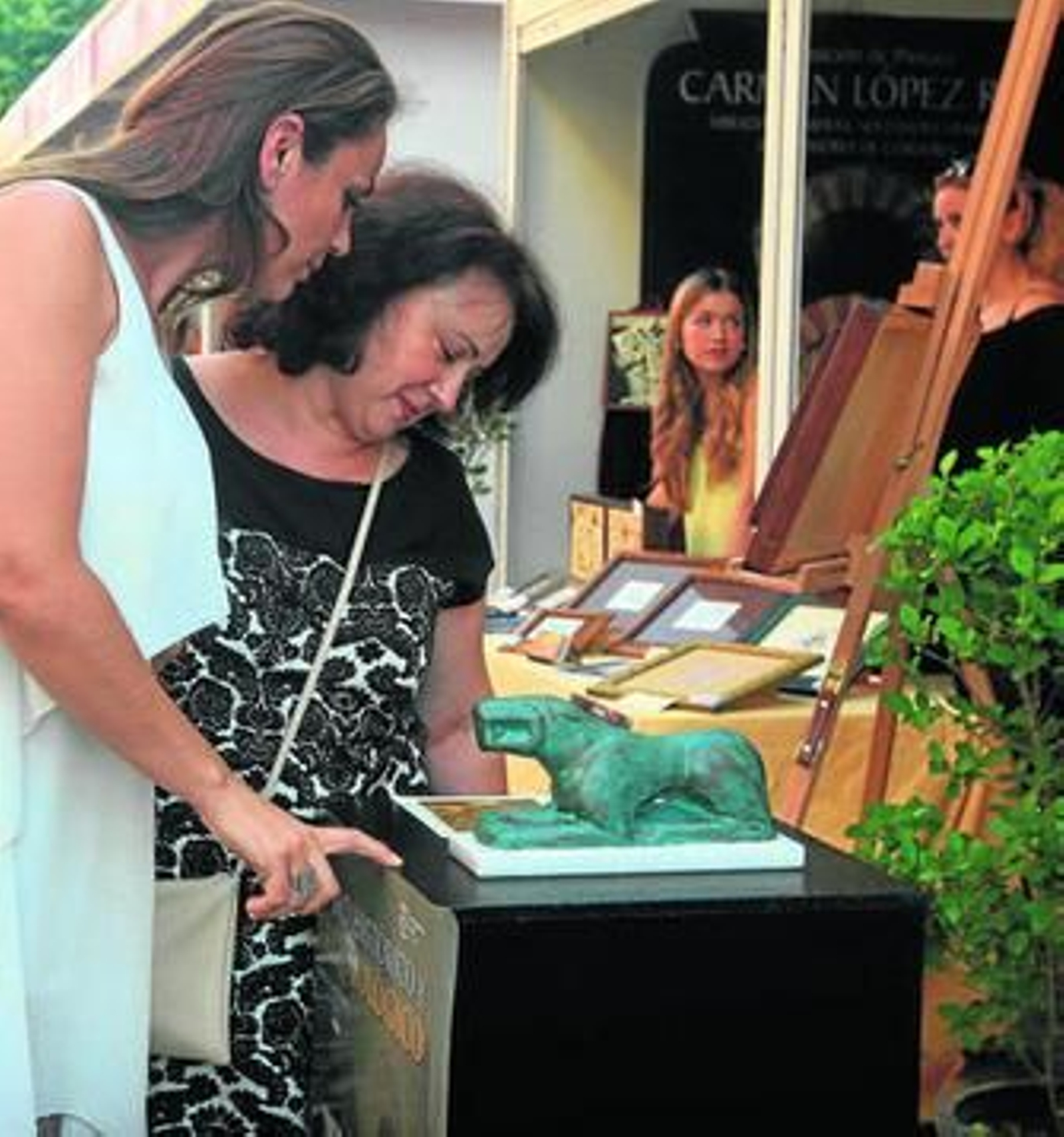 Varias viandantes se detienen en el expositor de Baena.