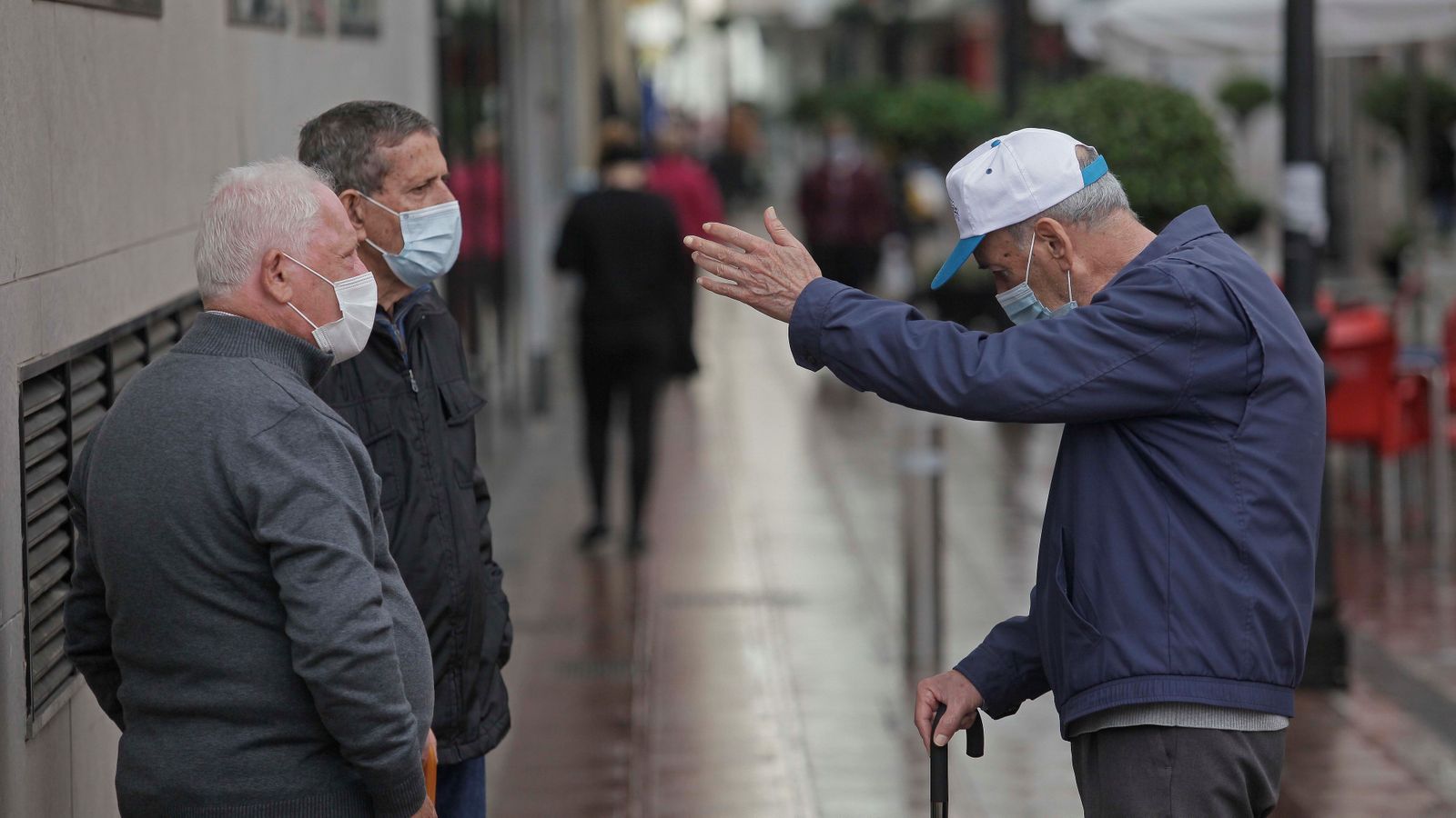 Tres hombres conversan en La Línea de la Concepción.