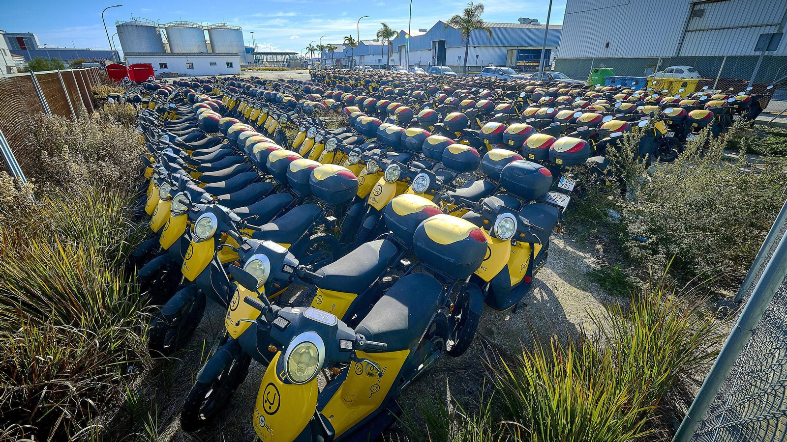 Motos de Muving almacenadas en un solar de Zona Franca.
