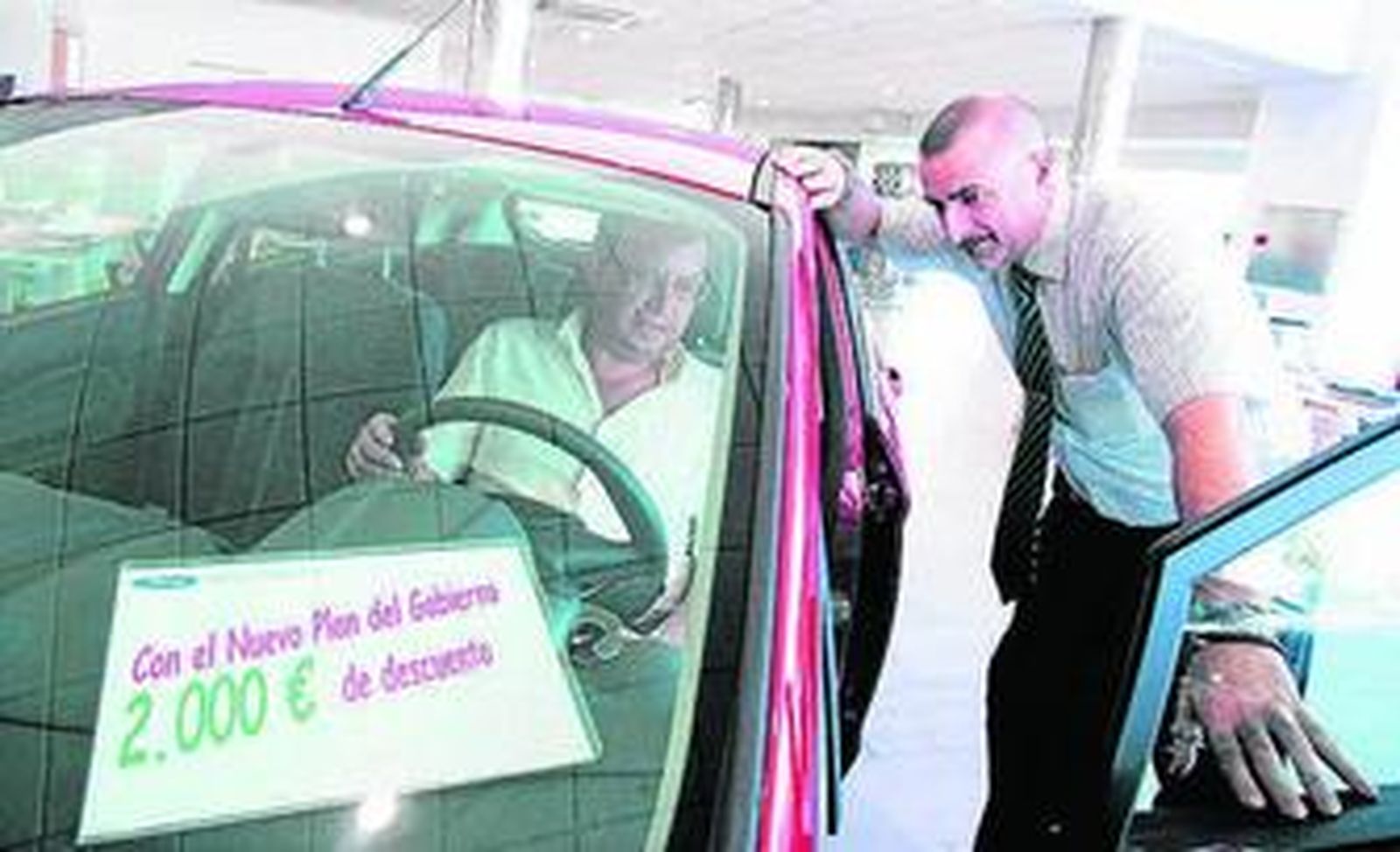 Un vendedor muestra un coche a un posible cliente.