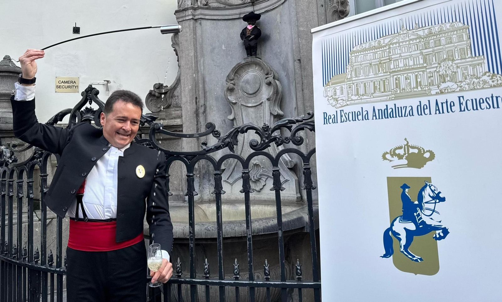 Jesús Rubiales, venenciando jerez ante el Manneken Pis vestido con el uniforme de gala de la Real Escuela.