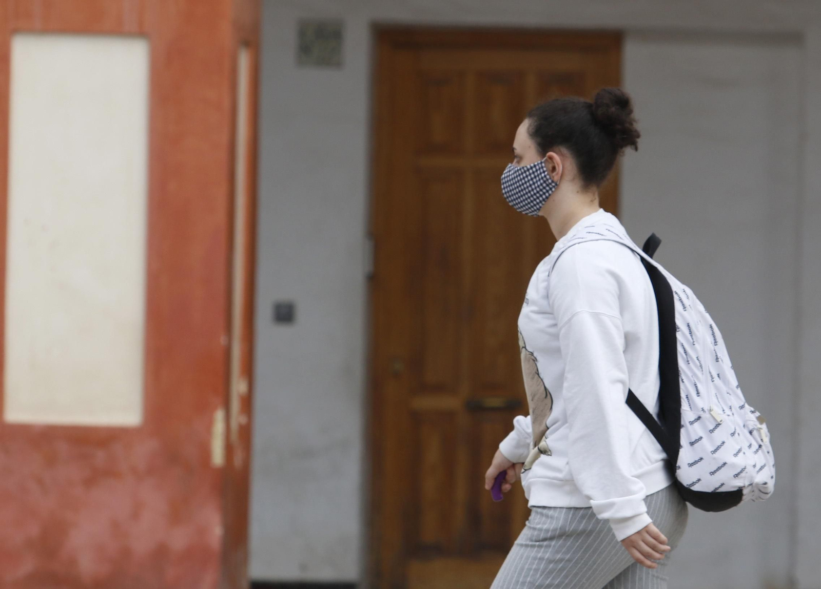 Una chica pasea con mascarilla por la plaza de la Corredera.