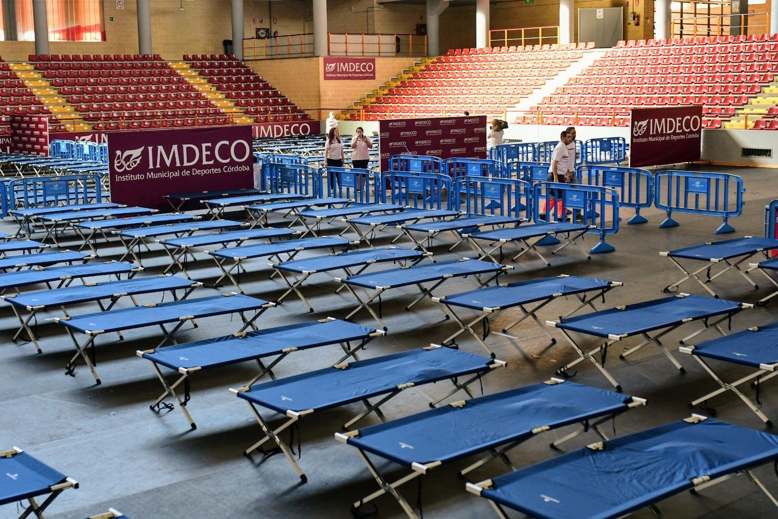 Los voluntarios de Cruz Roja colocan las camas para el descanso de los migrantes.