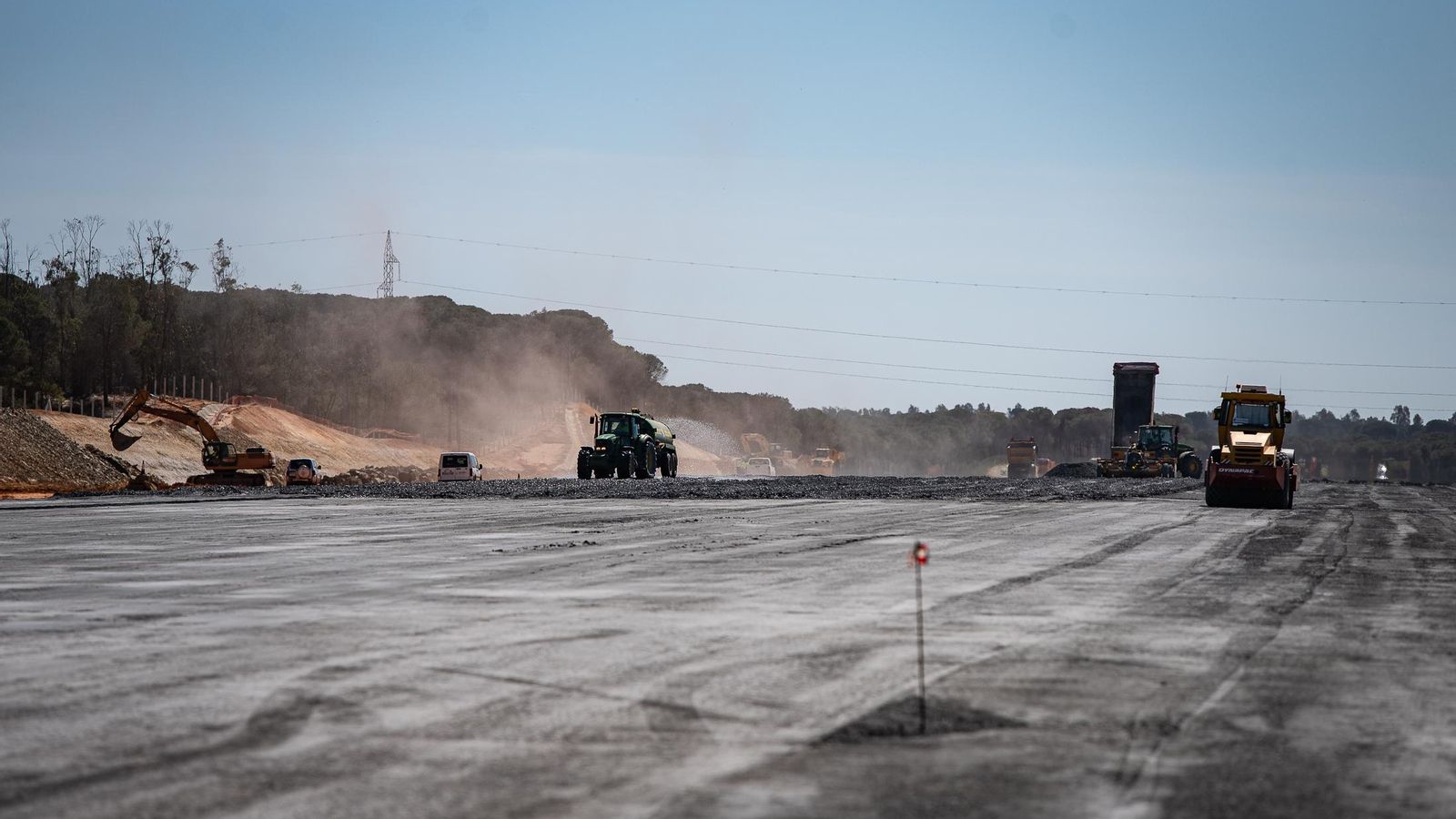 La pista con el tramo de zahorra compactada y la maquinaria trabajando