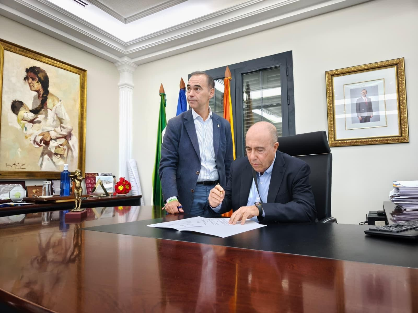 La firma del acuerdo entre el alcalde (I.) y el experto académico.