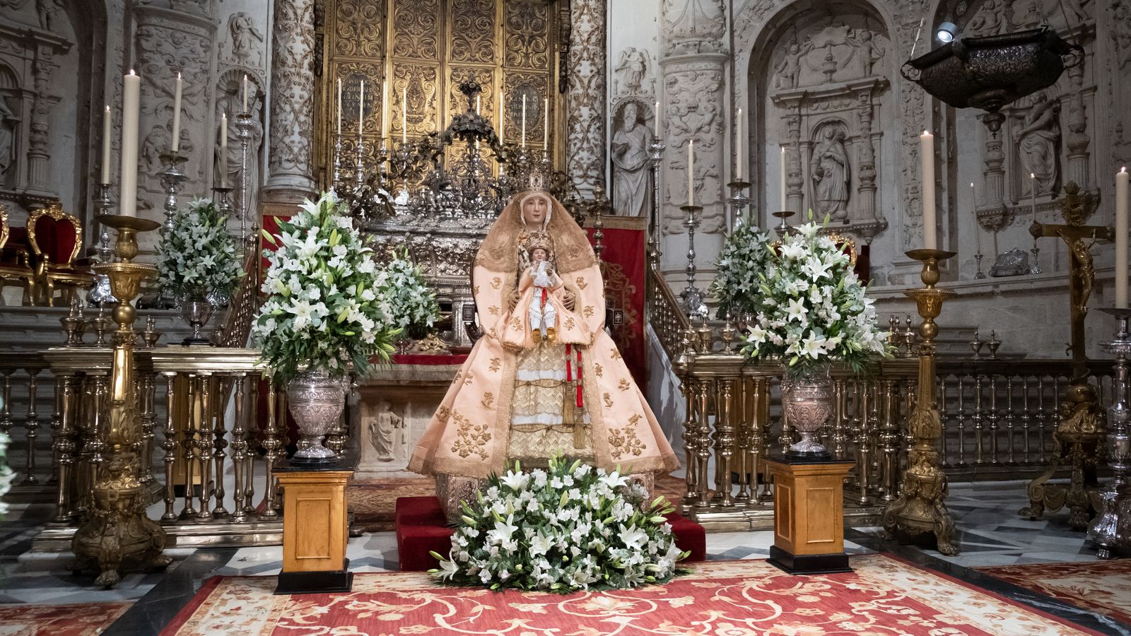 La Virgen de los Reyes rodeada de jarras de flores blancas durante su veneración