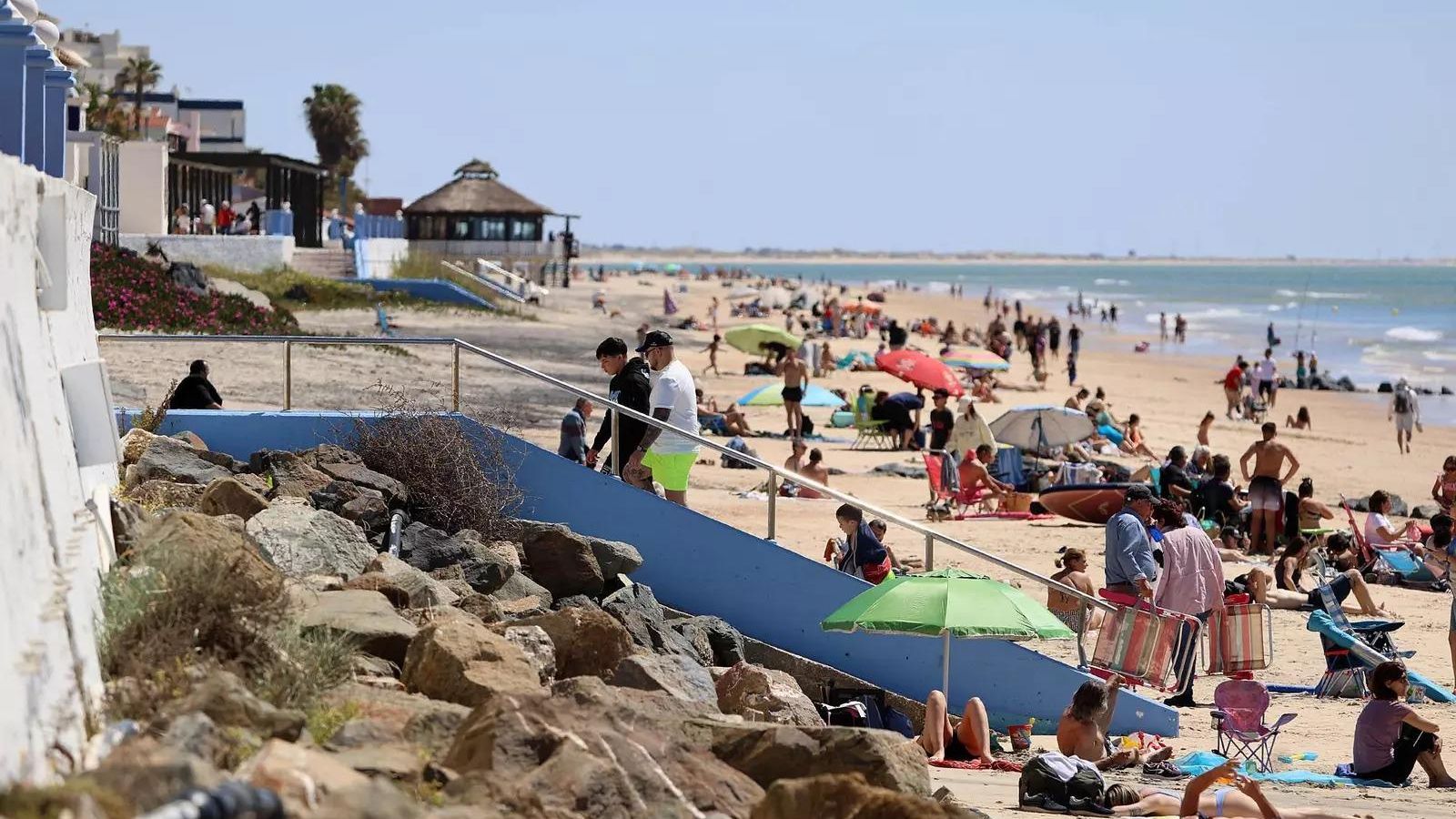 Playa llena de personas disfrutando de las agradables temperaturas de este domingo.