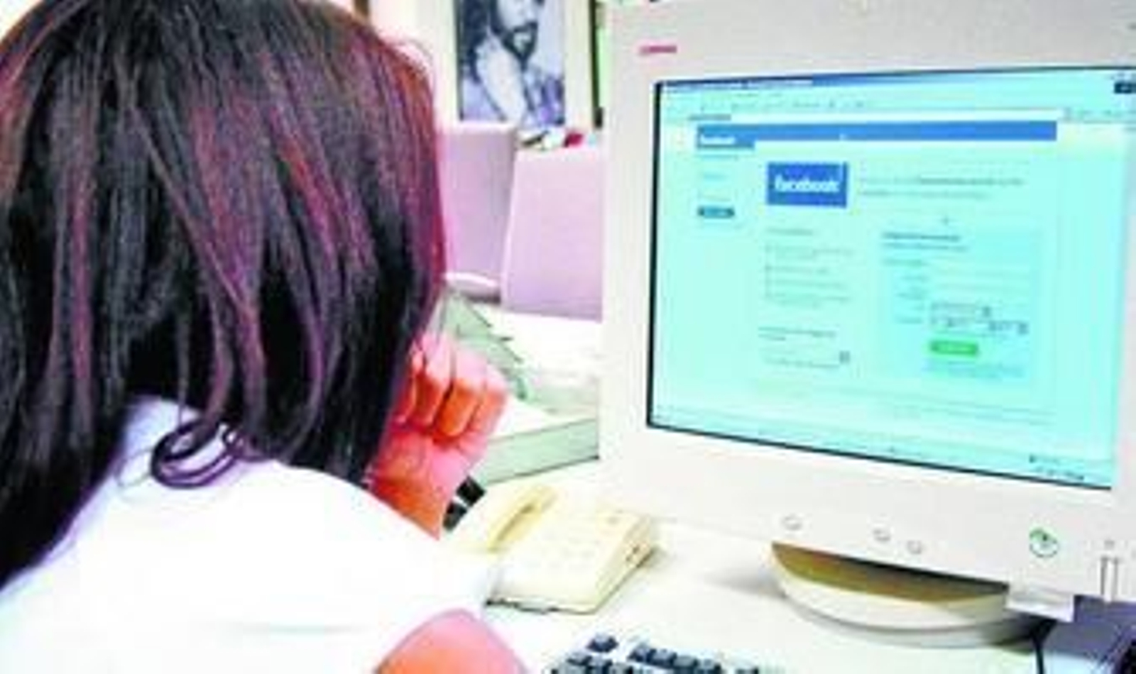 Una joven ante el ordenador conectada a las redes sociales de internet.