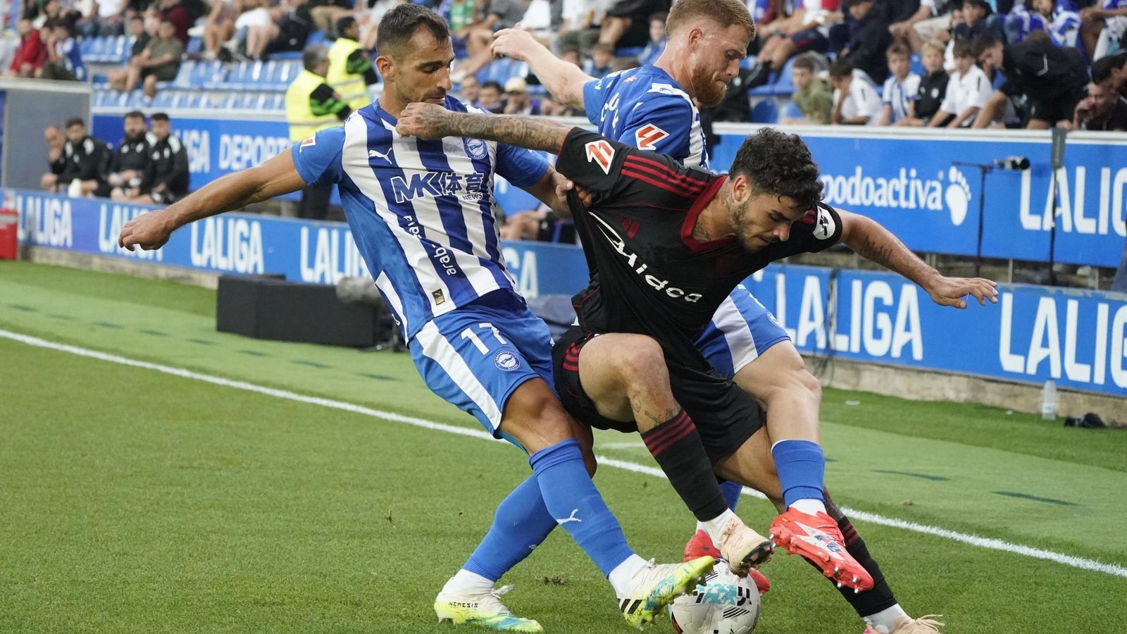 Isaac protege el balón ante dos rivales en el Alavés-Sevilla.