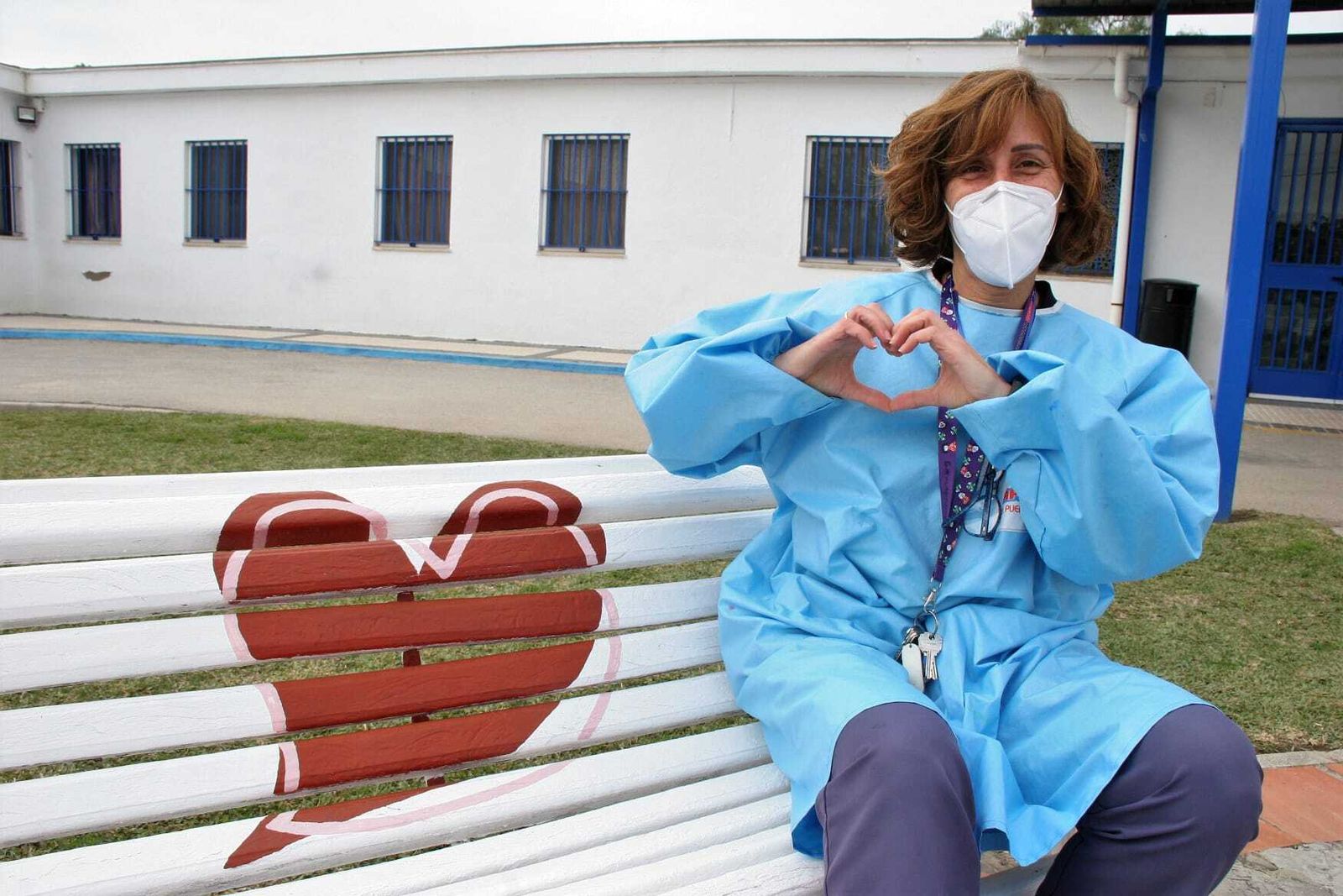 Rocío Sánchez Narváez hace la señal de un corazón a las puertas de la residencia de Afanas de El Puerto donde trabaja, donde se confinó para atender a los residentes enfermos y donde también ella se terminó contagiando.