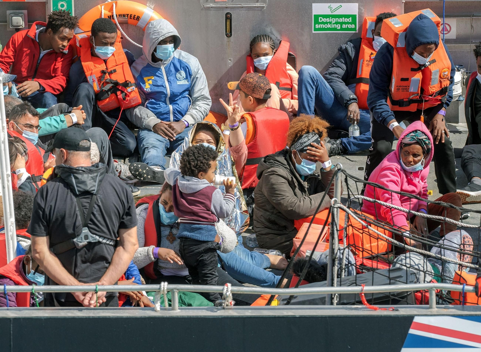 Migrantes llegan en un bote de rescate de Voluntarios de la Fuerza Fronteriza.