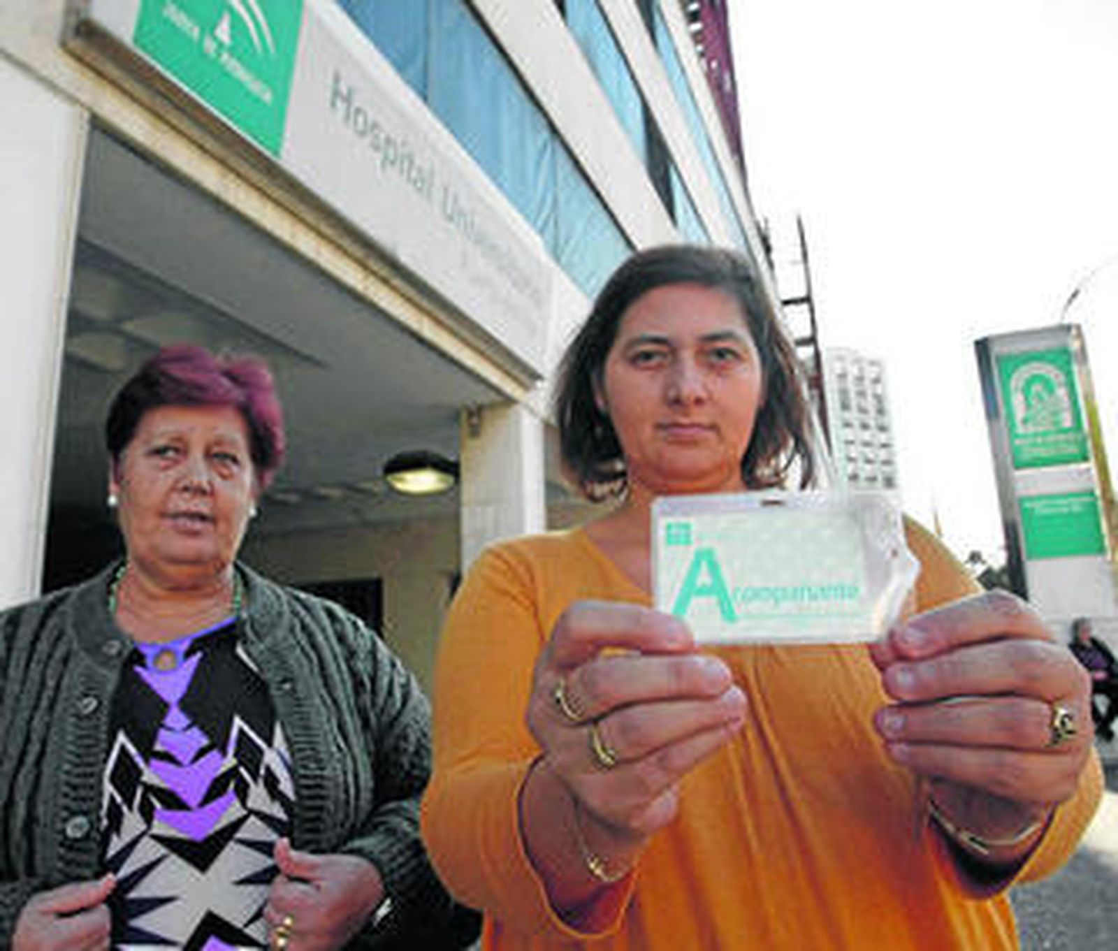 Una acompañante de un paciente hospitalizado muestra su tarjeta identificativa en la entrada del hospital.
