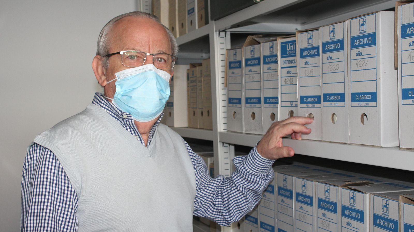 Gabriel Flores entre las numerosas cajas con documentos del archivo veratense.