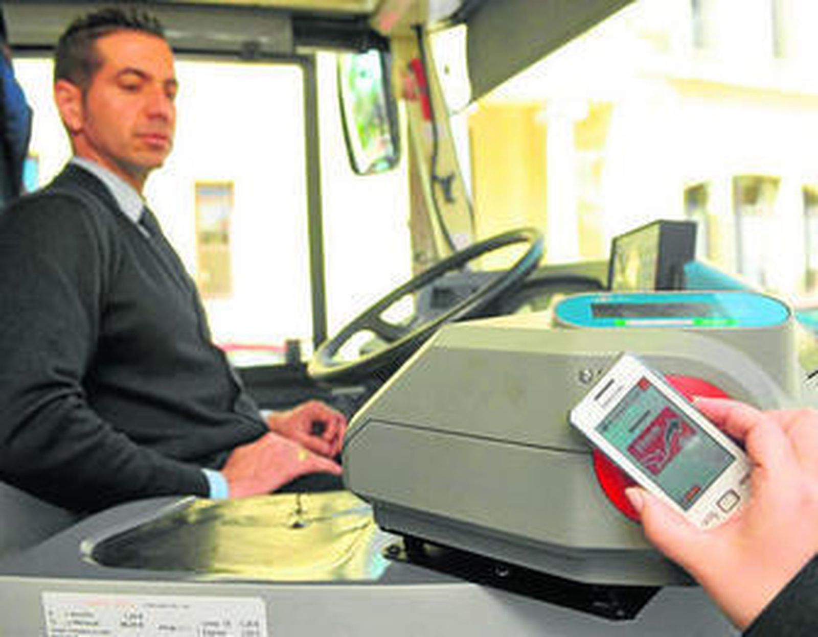 Un usuario paga el autobús a través del telefóno móvil.