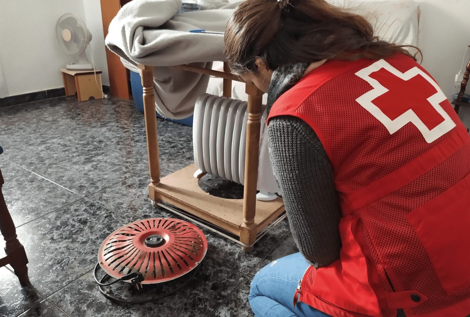 Un miembro de Cruz Roja ayuda a una familia en su ahorro energético.