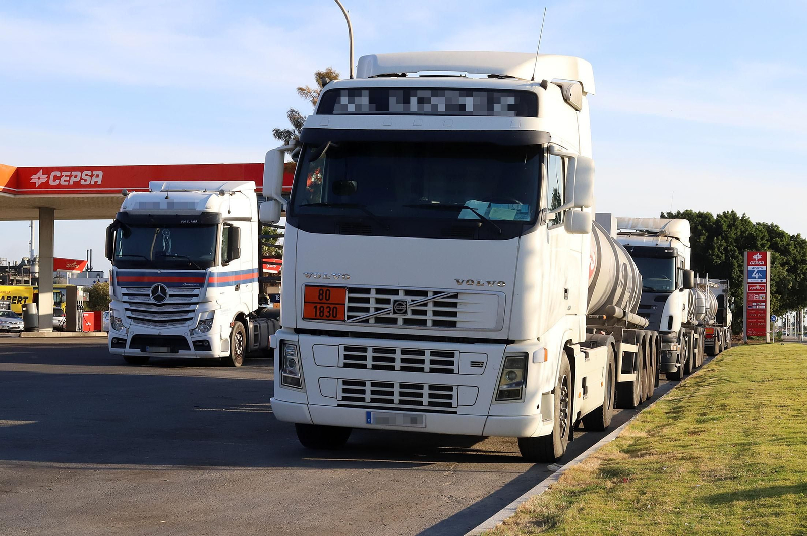Varios camiones en una gasolinera.