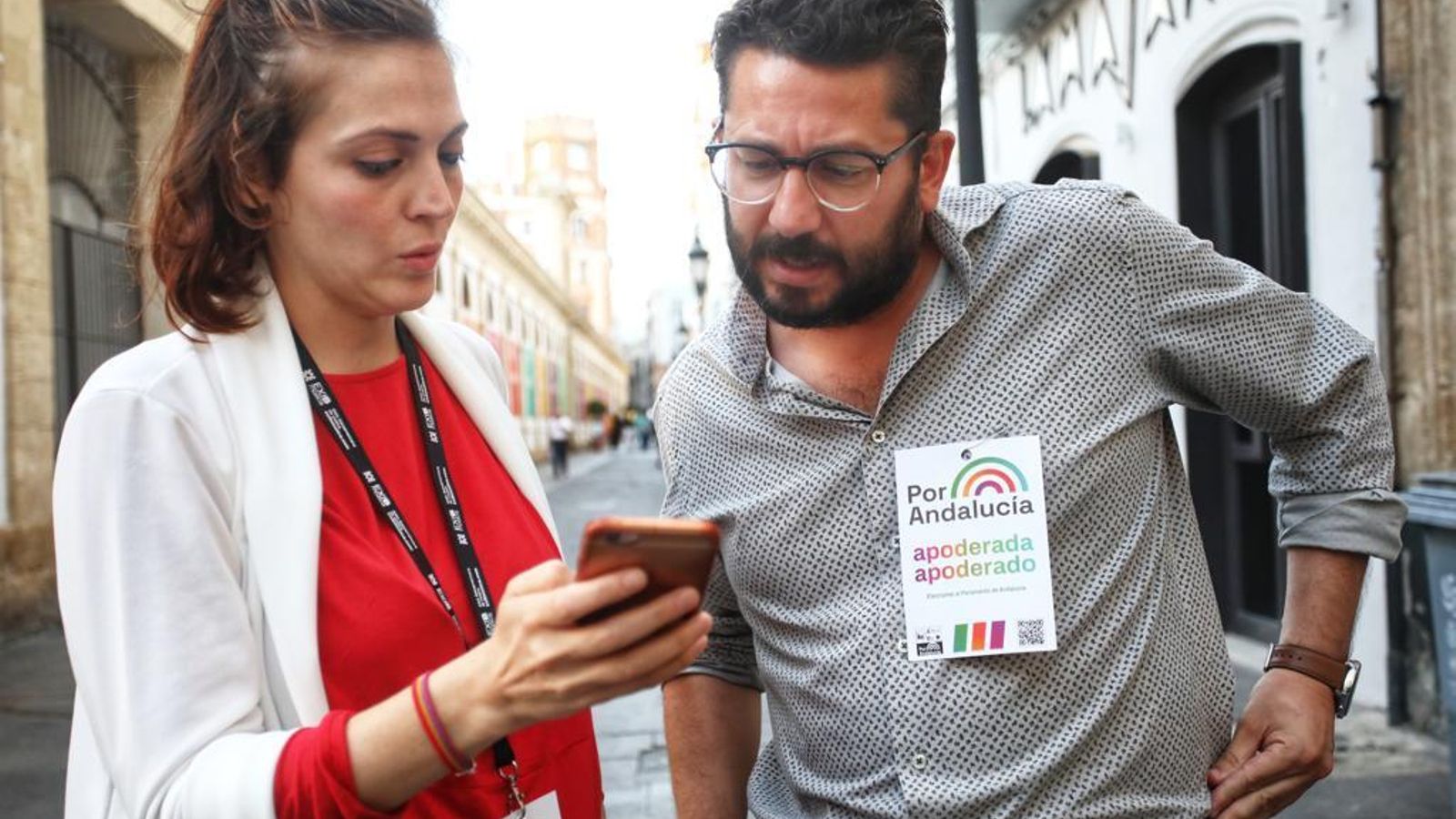 El coordinador provincial de IU con Ana Fernández consulta los resultados en los móviles delante de la sede de Ganar Cádiz.