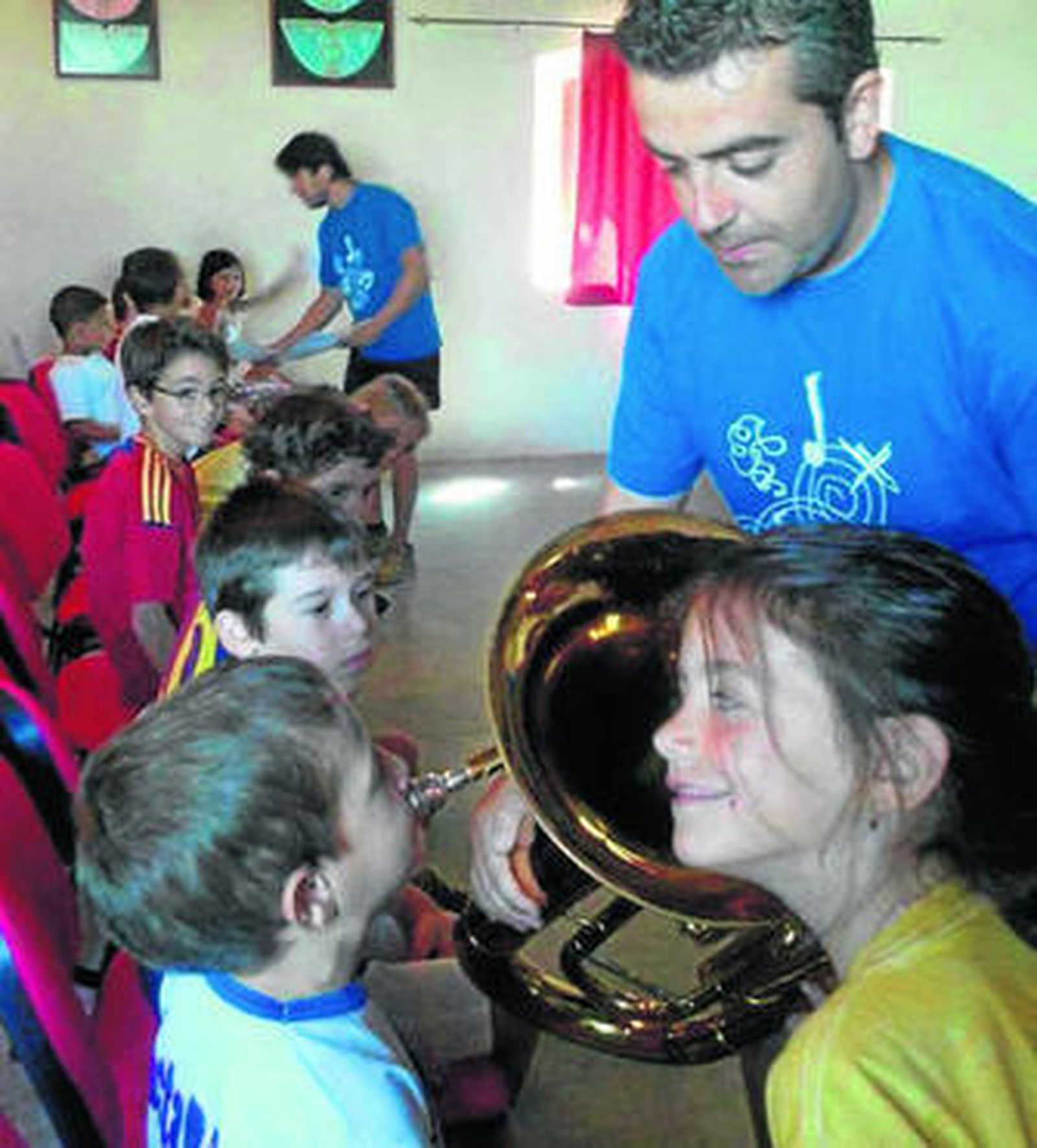 1. Unas alumnas de danza, haciendo un movimiento. 2. Un profesor enseña a los niños los secretos de la tuba en una de las aulas de la escuela.