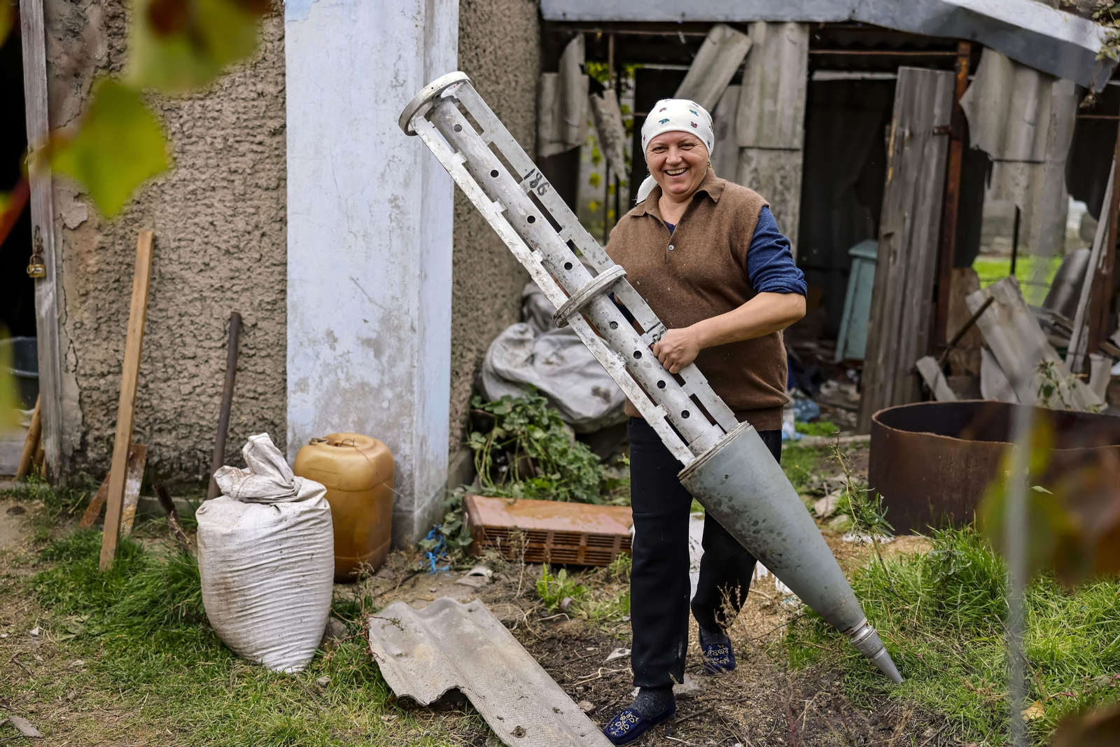 Una mujer muestra los restos de un cohete ruso, encontrado en su casa, después de que Ucrania haya recuperado este territorio.
