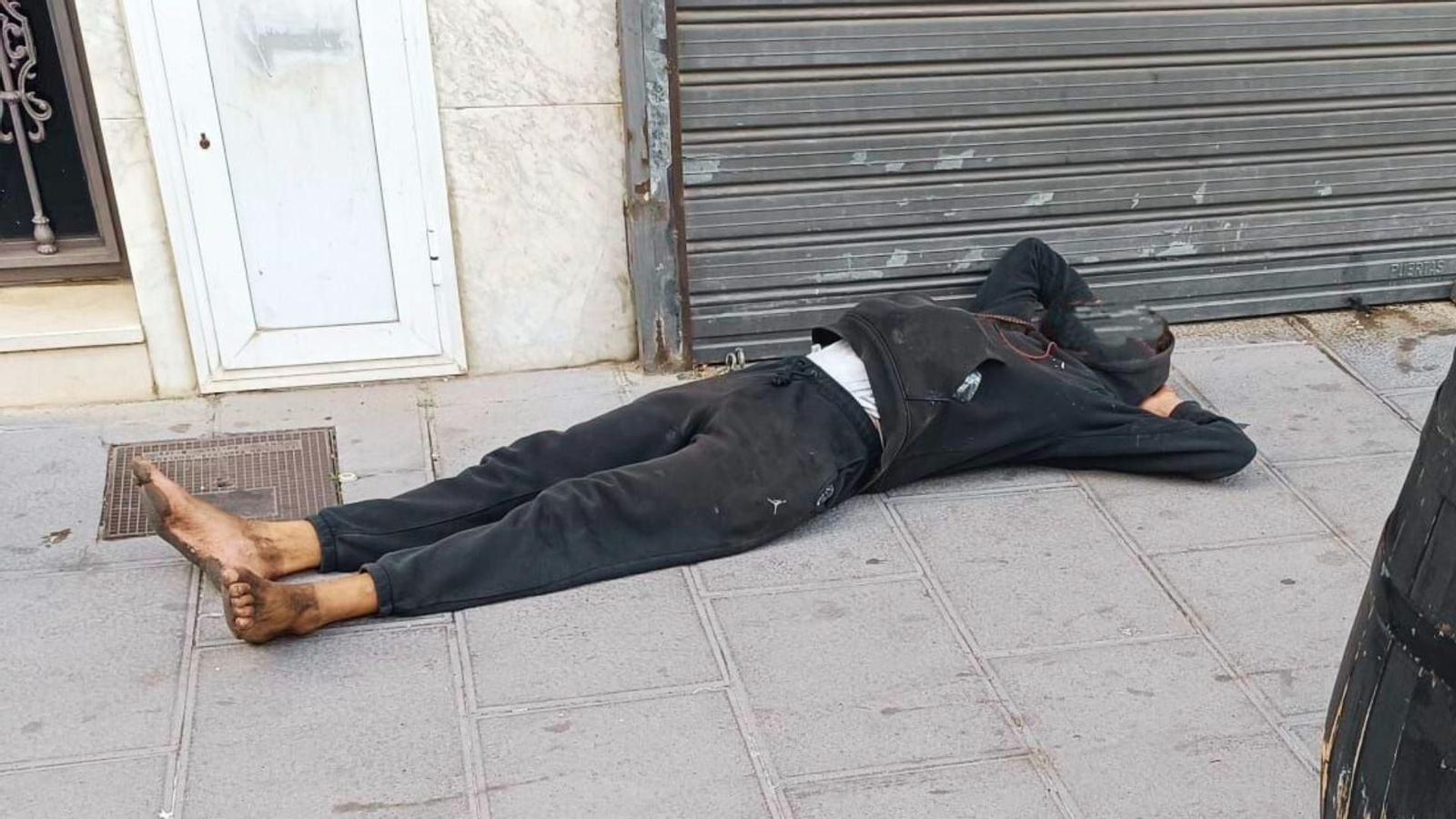 Un hombre tumbado, a plena luz del día, en la calle Tarifa, en Algeciras.
