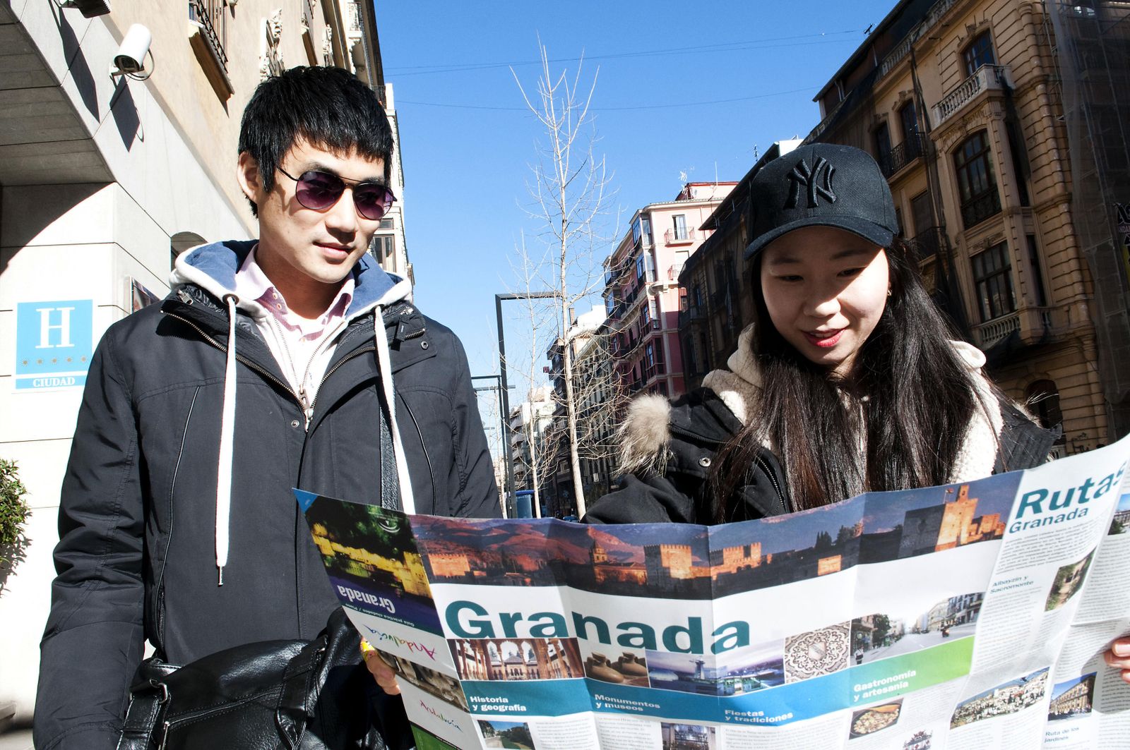 Imagen de archivo de dos turistas asiáticos consultando un mapa de Granada