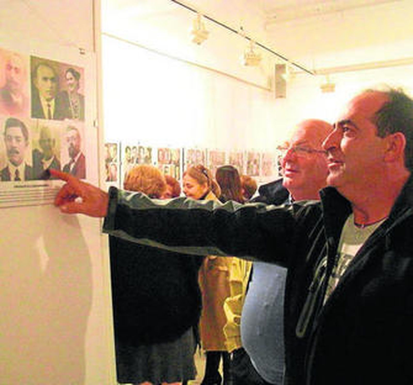 Dos vecinos observan algunas de las fotografías.