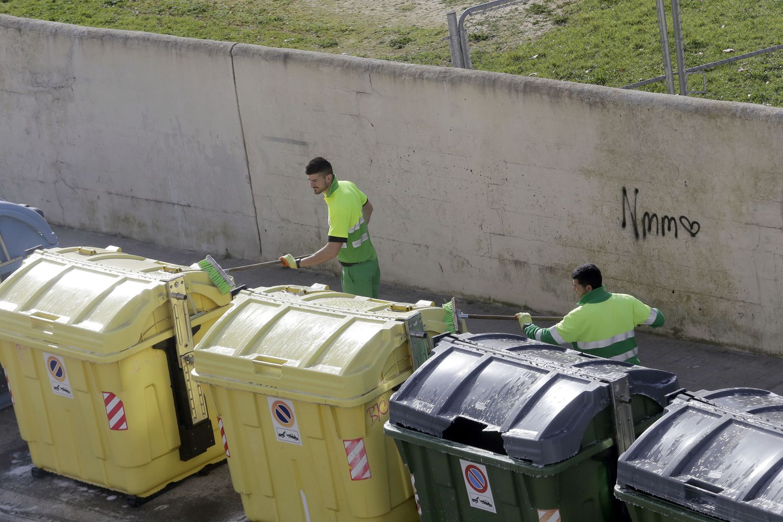 Dos trabajadores de Urbaser limpian contenedores, en una imagen reciente.