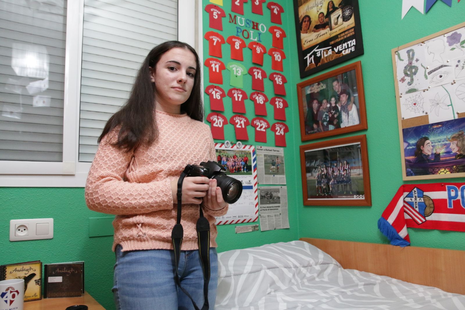 Davinia Capel posa con la cámara en su habitación, decorada del Poli Almería