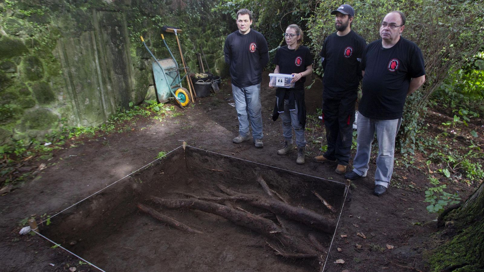 Varios operarios junto al antiguo cementerio de Poio  donde se ha encontrado un hueso, y donde nuevos estudios en la iglesia vieja de Poio  procurarán encontrar ADN de Colón  y certificar la teoría de que era gallego