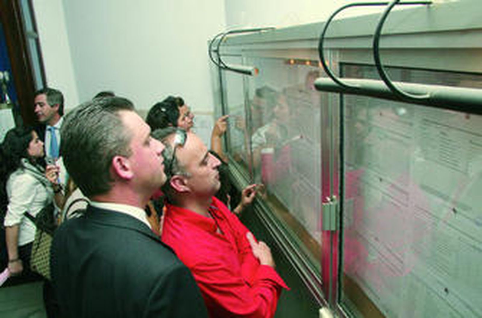 Los padres comprueban la listas de admitidos de un colegio.