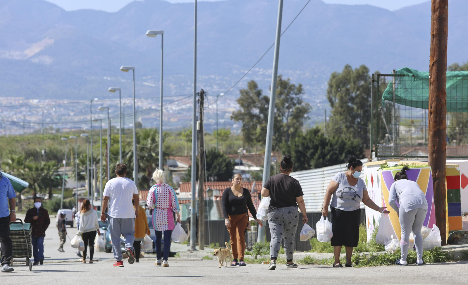 Vecinos de Los Asperones acuden a uno de los repartos de comida en el barrio.