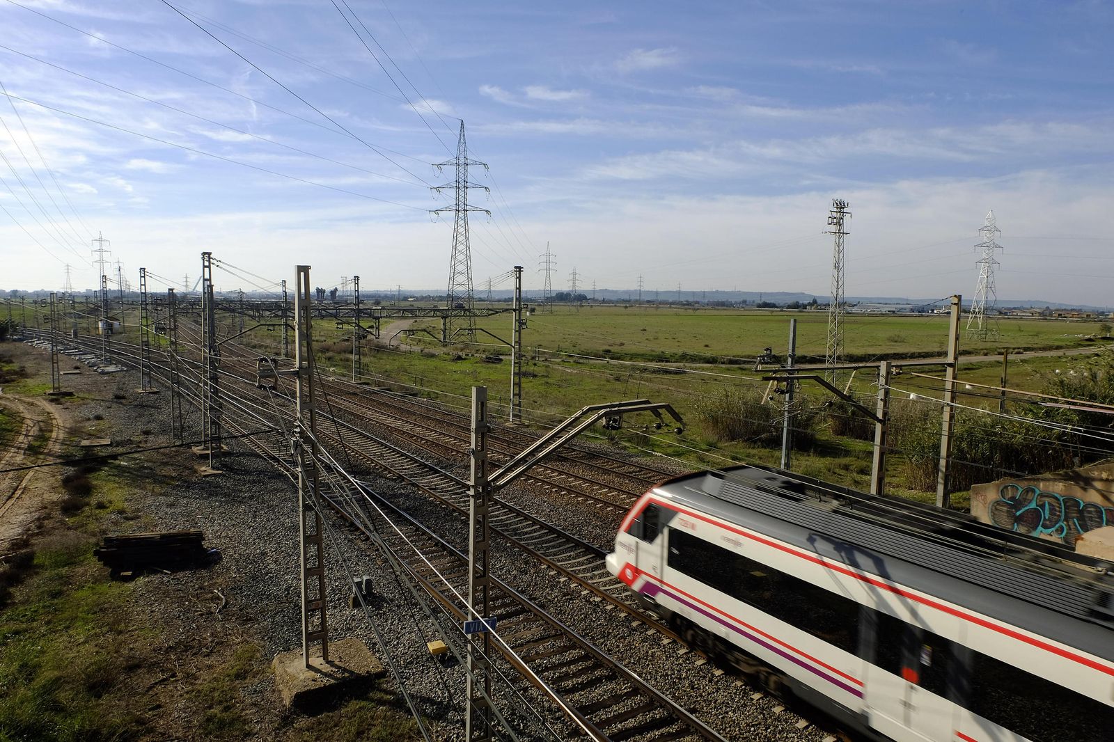 Un tren de viajeros pasa junto a la parcela de Majarabique, situada a la derecha de la imagen.