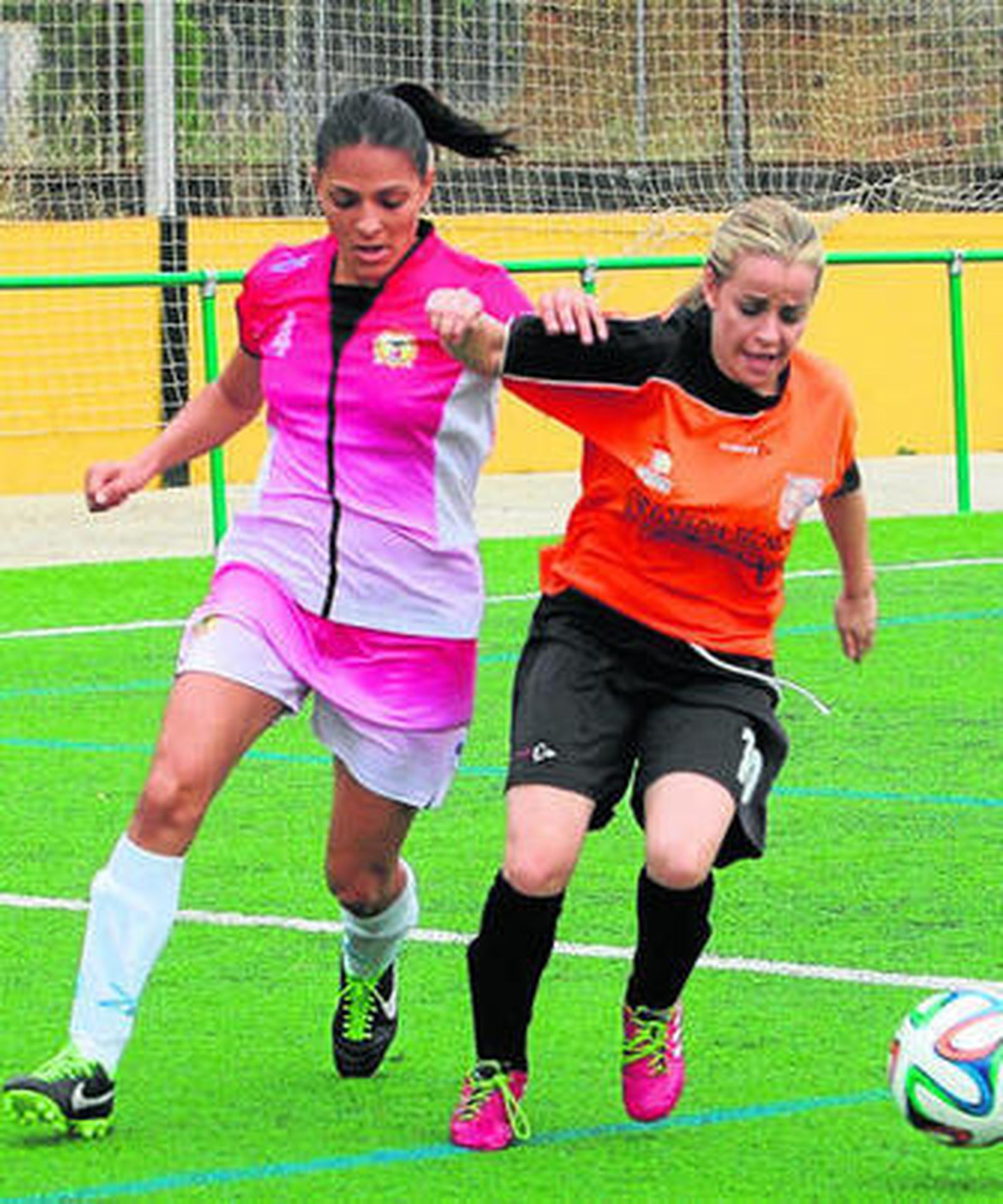Una jugadora de El Naranjo se lleva el balón ante una rambleña.