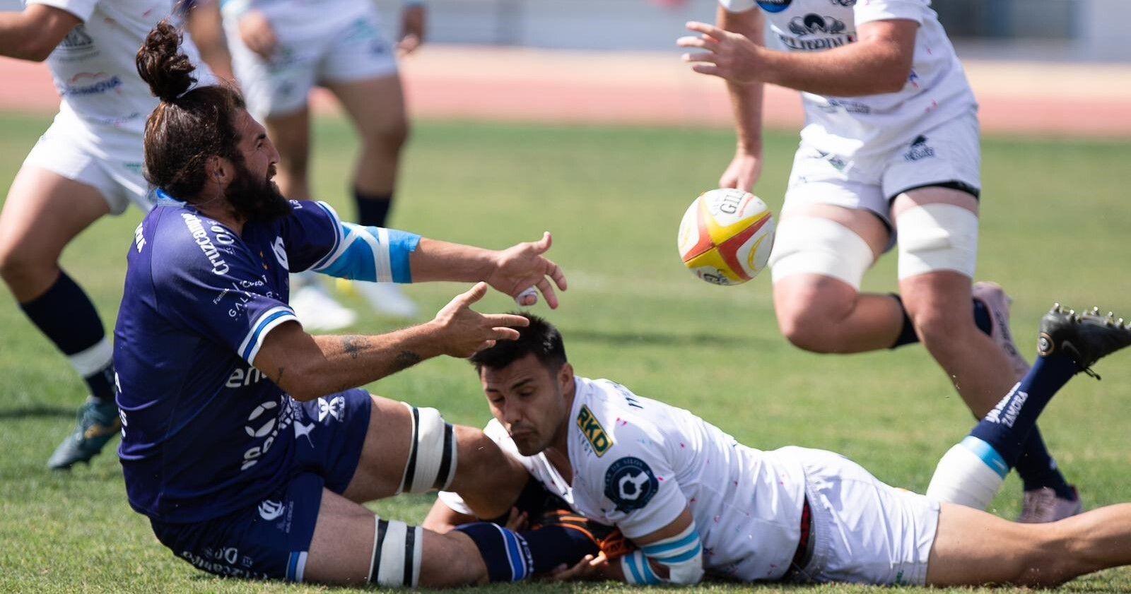 Manu Mora intenta jugar hacia atrás tras ser placado.