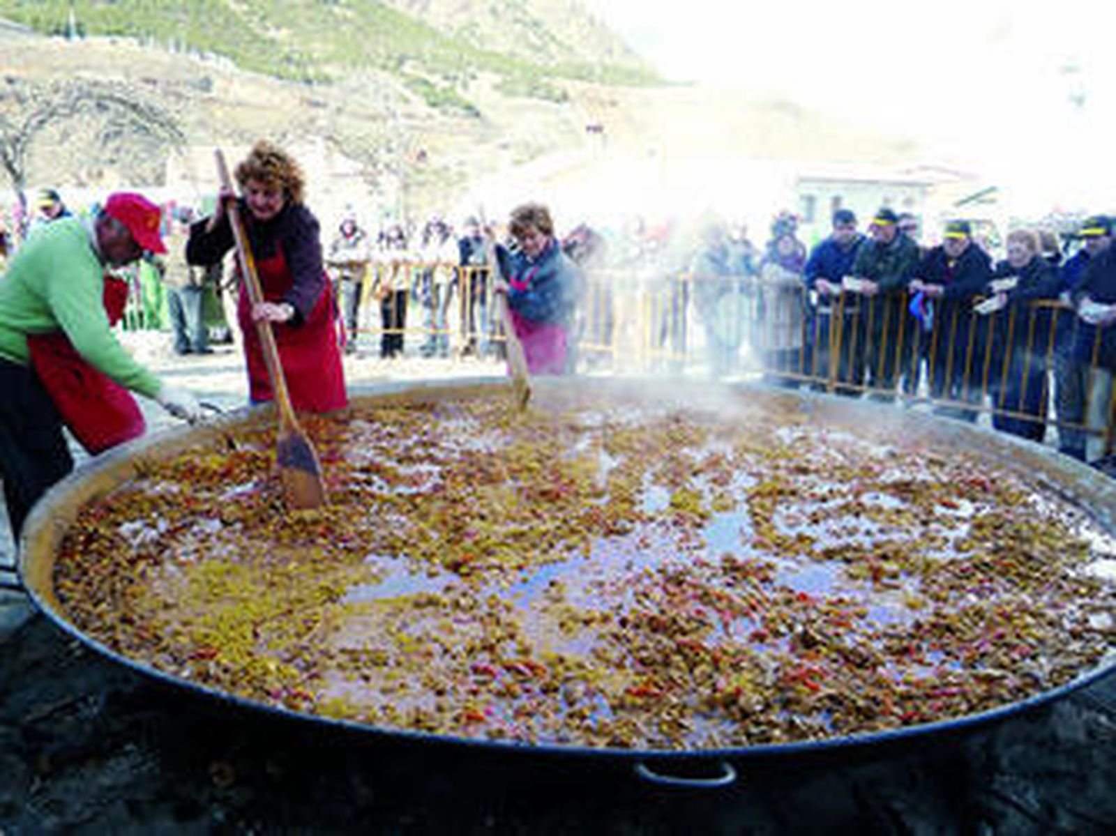 Javier, Maribel y Benita ultiman la paella a la vista de cientos de romeros.