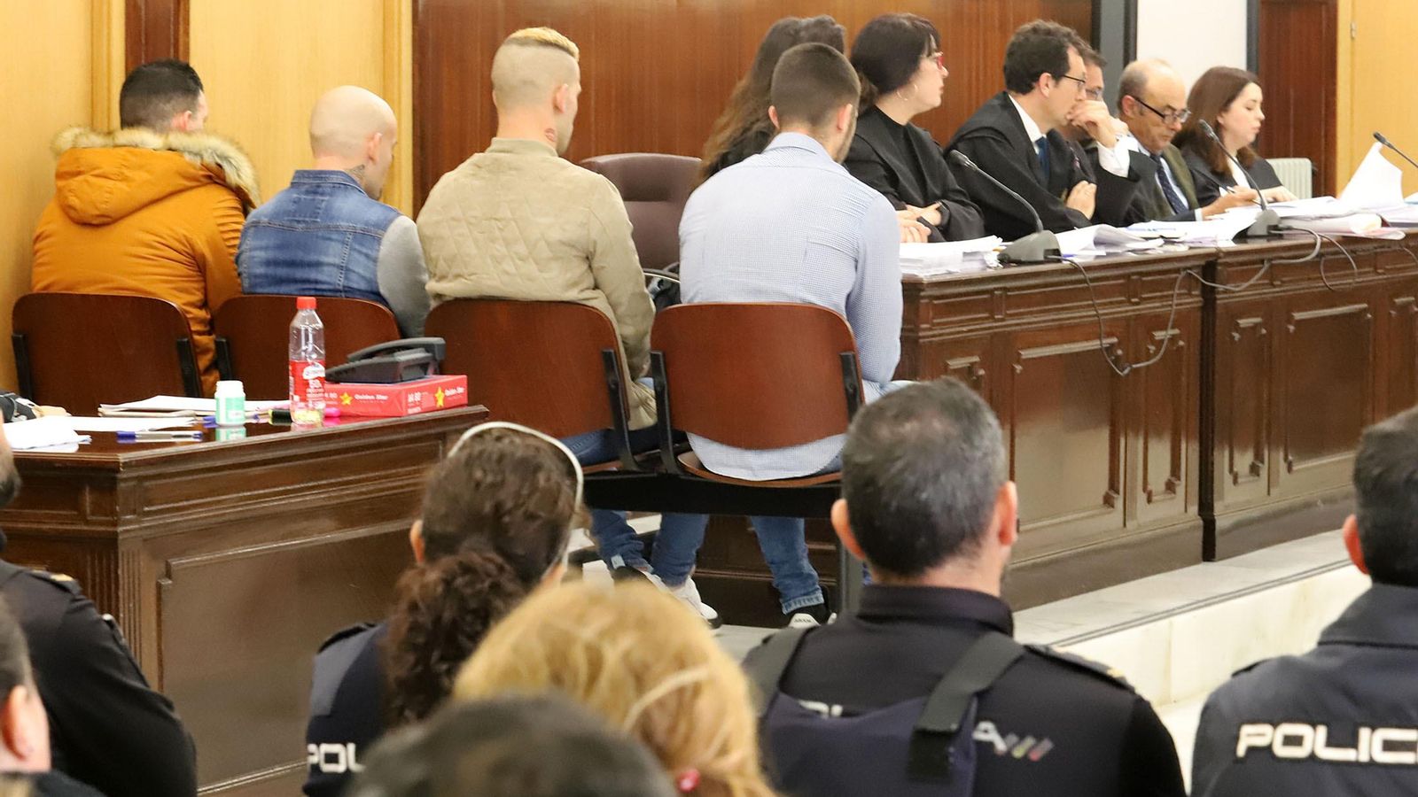 Los cuatro acusados en el banquillo, de espaldas al público, en la primera sesión del juicio del crimen de El Campillo.